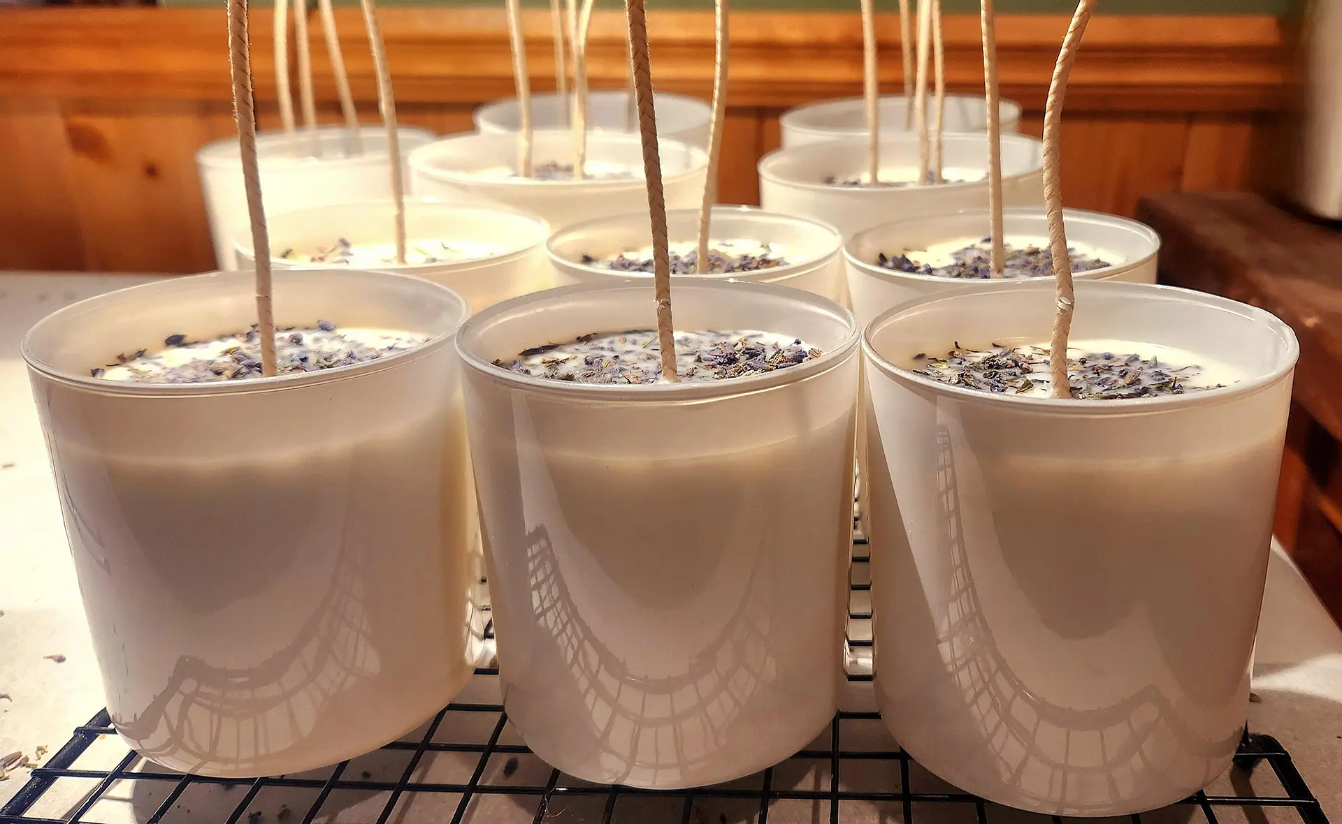 Rows of handmade Peaceful Valley candles curing on workshop shelves